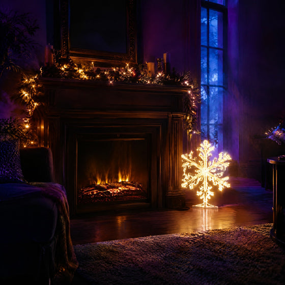 Décoration lumineuse de Noël : guirlande LED blanc chaud sur une cheminée et motif flocon lumineux dans un salon