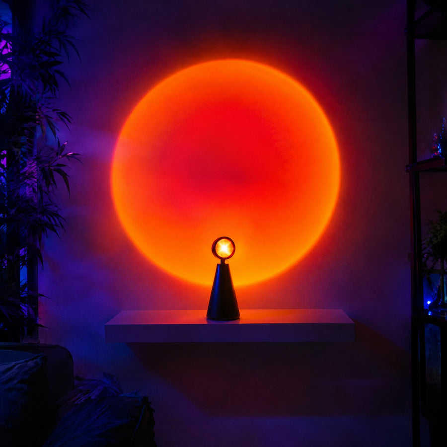 Lampe coucher de soleil projetant un grand halo orangé sur un mur blanc depuis une étagère dans un studio sombre