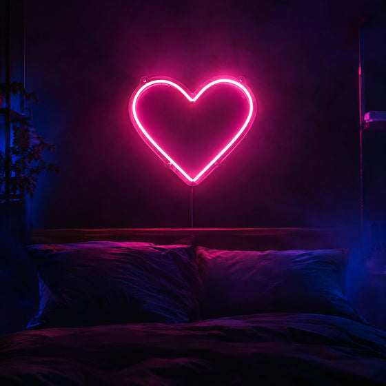Néons personnalisés : cœur rose en tube néon LED sur fond acrylique transparent au-dessus d'un lit dans une chambre