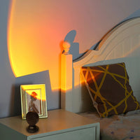 Projecteur coucher de soleil USB – posé sur une table de nuit près d'un lit