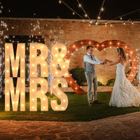 Lettre marquee 120 cm – lettres MR & MRS devant un cœur lumineux dans un jardin