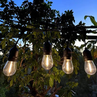 Guirlande guinguette S14 E27 – ampoules allumées sous une pergola de jardin