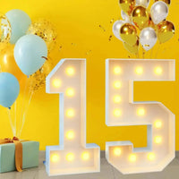 Chiffre lumineux géant – nombre 15 devant des ballons dorés et bleus
