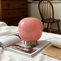 Lampe de table en verre à 3 teintes – lampe rose sur un lit avec un magazine