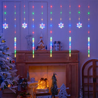 Rideau lumineux flocons et glaçons de Noël – flocons et glaçons multicolores devant une cheminée