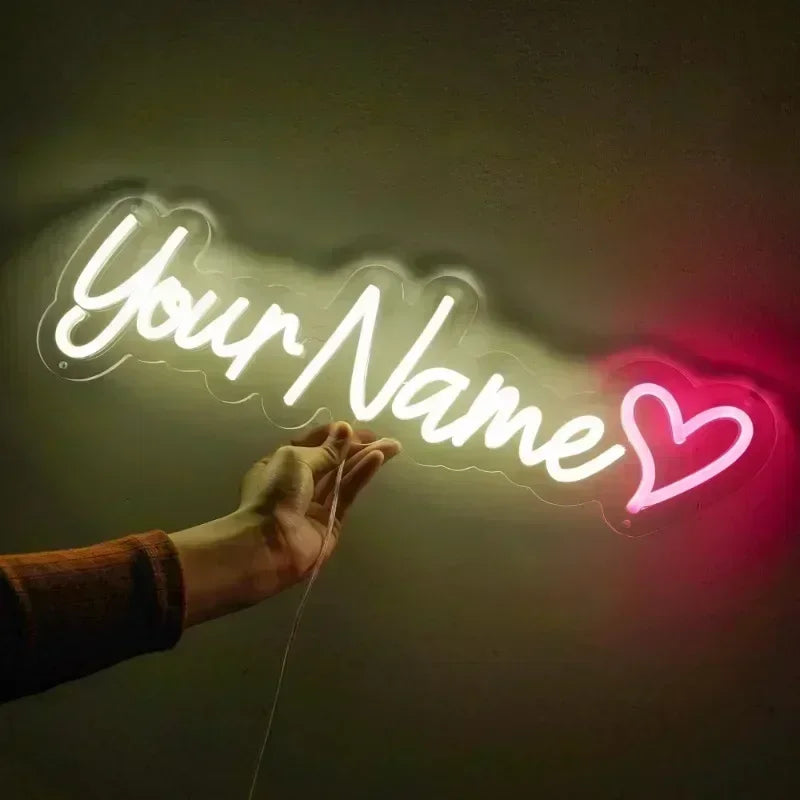 Néon texte personnalisé – exemple sur une ligne : texte blanc avec un cœur rose tenu à la main