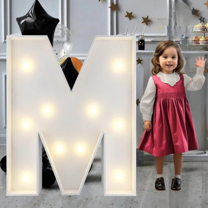 Lettre marquee 120 cm – la lettre M allumée à côté d'une petite fille