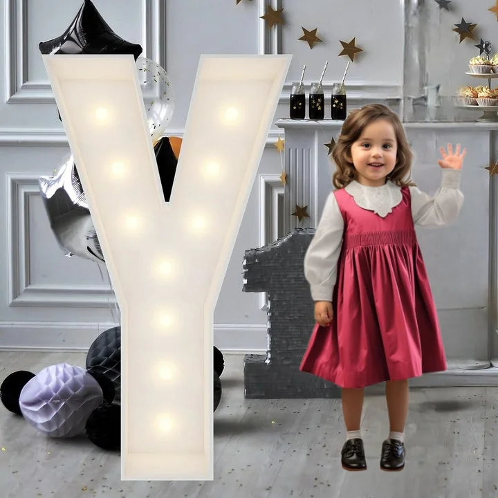 Lettre marquee 120 cm – la lettre Y allumée à côté d'une petite fille