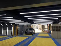 Barres LED murales de détailing – lignes de barres LED au plafond d'un garage aux sols jaunes et bleus