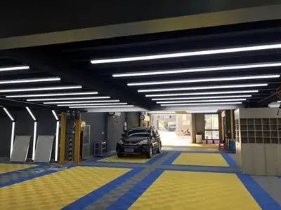 Barres LED murales de détailing – lignes de barres LED au plafond d'un garage aux sols jaunes et bleus