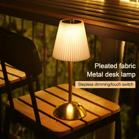Lampe de table sans fil plissée – allumée sur une table en bois