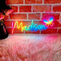 Néon prénom personnalisé RGB multicolore – néon prénom « Madison » avec papillon sur un mur de briques