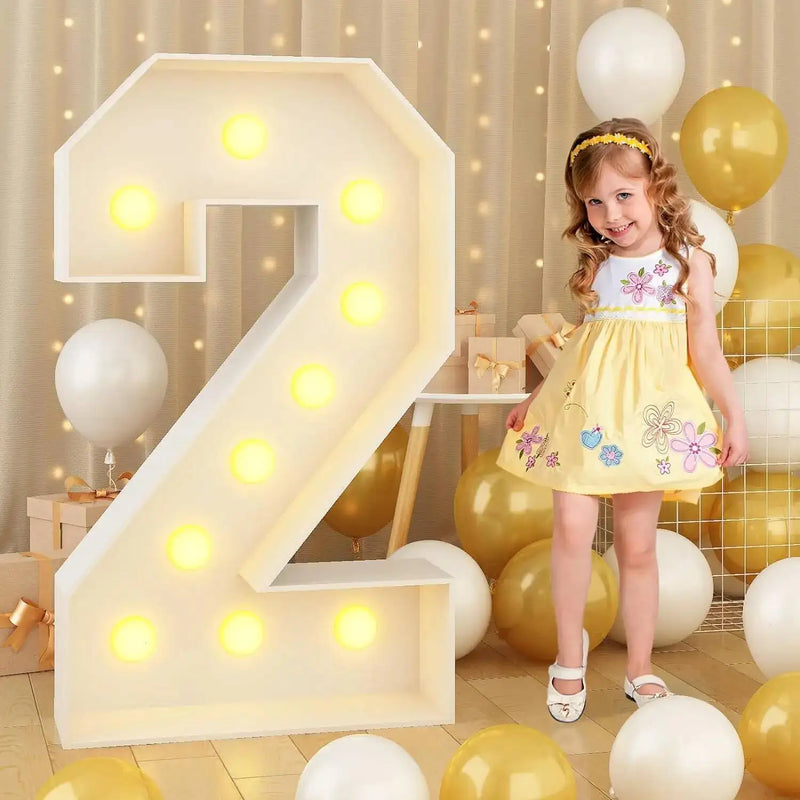 Chiffre lumineux géant – chiffre 2 allumé à côté d'une petite fille