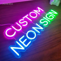 Néon personnalisé LED – exemple en lettres capitales violettes, bleues et vertes posé sur un parquet