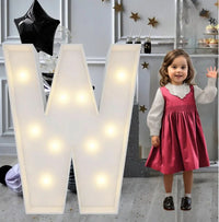 Lettre marquee 120 cm – la lettre W allumée à côté d'une petite fille