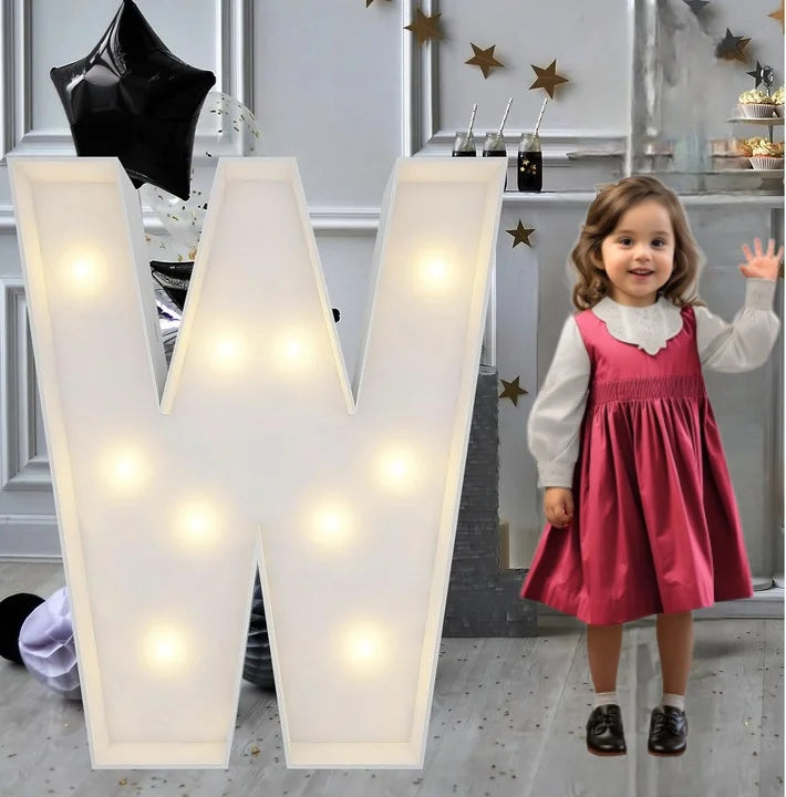 Lettre marquee 120 cm – la lettre W allumée à côté d'une petite fille