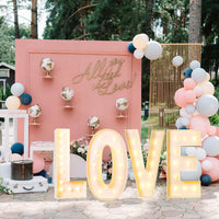 Lettre marquee 120 cm – mot LOVE allumé devant un décor rose et bleu