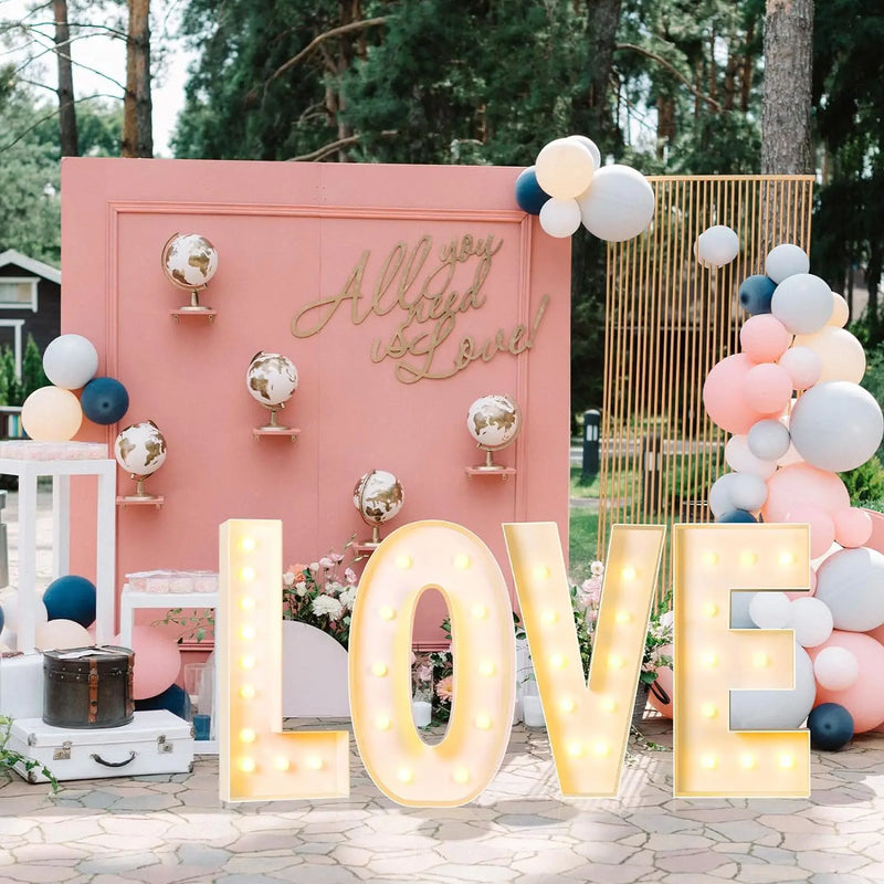 Lettre marquee 120 cm – mot LOVE allumé devant un décor rose et bleu