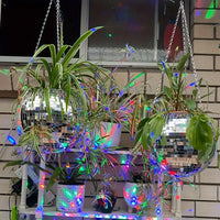 Jardinière boule à facettes – boules suspendues sur un balcon sous des lumières colorées