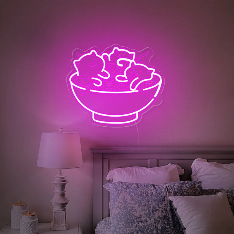 Néon chats et ramen – coloris rose allumé au-dessus d'un lit