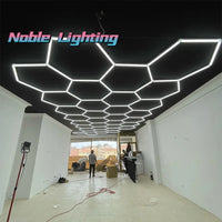 Plafonnier LED hexagonal – plafond hexagonal allumé dans un local commercial à grande baie vitrée