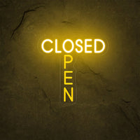 Panneau OPEN CLOSED en néon LED – version jaune doré sur un mur de pierre