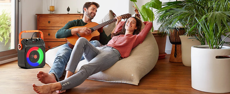 Enceinte karaoké familiale – enceinte lumineuse dans un salon avec une guitare