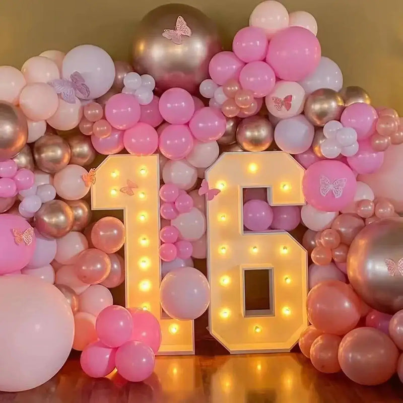 Chiffre lumineux géant – nombre 16 devant un décor de ballons roses et de papillons