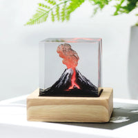 Lampe volcan ou champignon atomique en résine LED – cube à volcan sur socle en bois clair près d'une plante