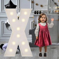 Lettre marquee 120 cm – la lettre X allumée à côté d'une petite fille