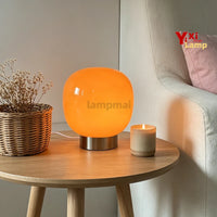 Lampe de table en verre à 3 teintes – lampe orange sur une table basse avec une bougie