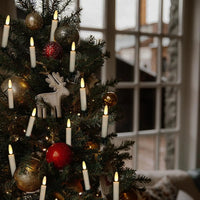 Bougies LED à clip – sapin de Noël décoré de bougies à clip près d'une fenêtre