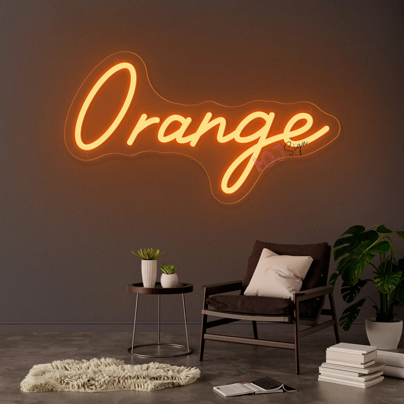 Néon prénom personnalisé cœur ou couronne – texte orange sur un mur gris au-dessus d'un fauteuil