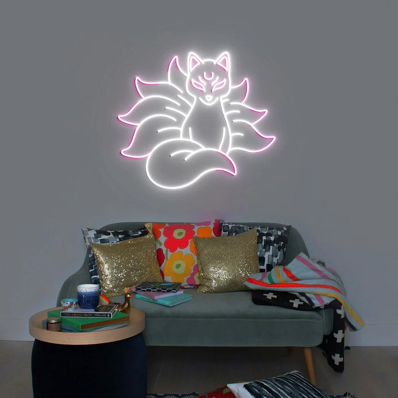 Néon renard kitsune – coloris blanc et rose allumé au-dessus d'un canapé