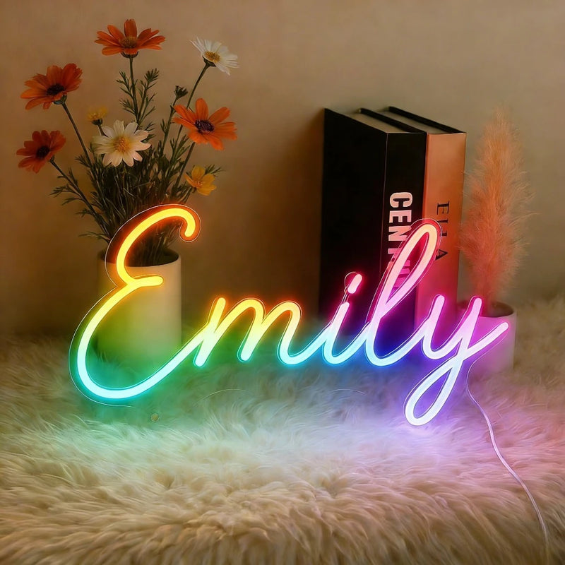 Néon prénom personnalisé RGB multicolore – néon prénom « Emily » posé sur un tapis près de fleurs