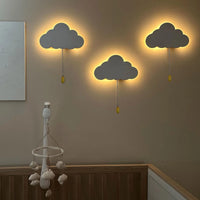 Veilleuse murale enfant nuage – trois nuages gris allumés au-dessus d'un berceau