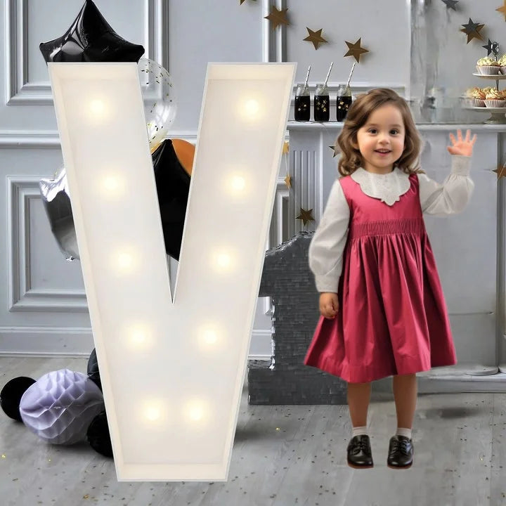 Lettre marquee 120 cm – la lettre V allumée à côté d'une petite fille