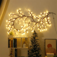 Guirlande de saule lumineuse – vigne lumineuse sur un mur de salon près d'un sapin