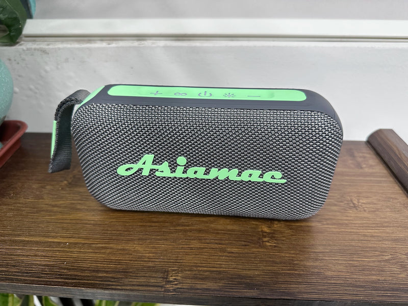 Enceinte Bluetooth lumineuse portable – version gris et vert menthe posée sur une table