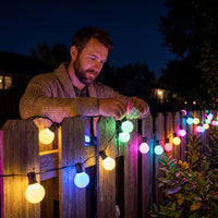 Guirlande guinguette WiFi G40 – accrochée à une clôture de jardin, ampoules multicolores allumées