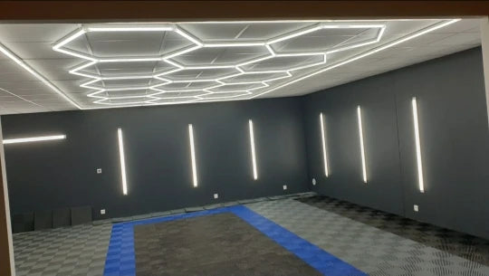 Barres LED murales de détailing – hexagones au plafond et barres verticales sur les murs d'un atelier