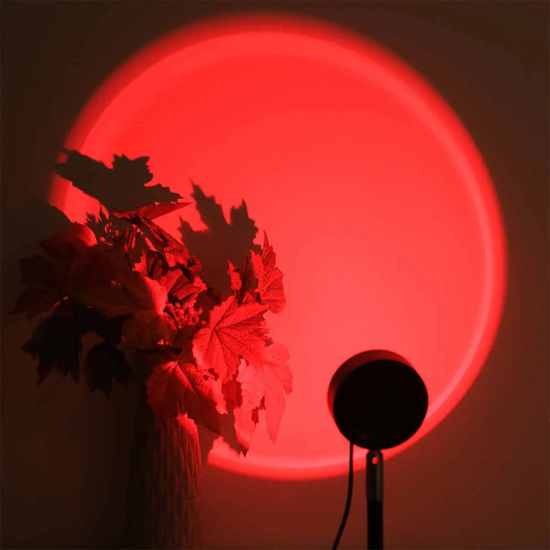 Lampe coucher de soleil sur pied 24 cm – projection rouge sur un mur avec des plantes