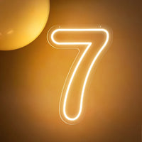 Chiffre néon LED blanc chaud – le chiffre 7 allumé sur un mur doré