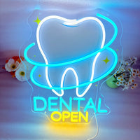 Enseigne néon dentiste DENTAL OPEN – gros plan sur un mur clair avec des fleurs