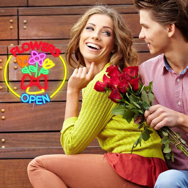 Enseigne néon fleuriste FLOWERS OPEN – en situation, couple avec un bouquet de roses