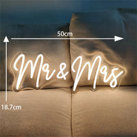 Néon mariage – « Mr & Mrs » de 50 x 18,7 cm en blanc chaud sur un canapé