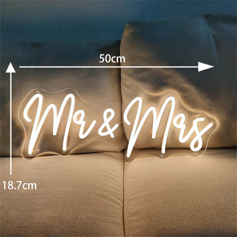Néon mariage – « Mr & Mrs » de 50 x 18,7 cm en blanc chaud sur un canapé