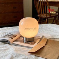 Lampe de table en verre à 3 teintes – lampe allumée en lumière chaude sur un lit
