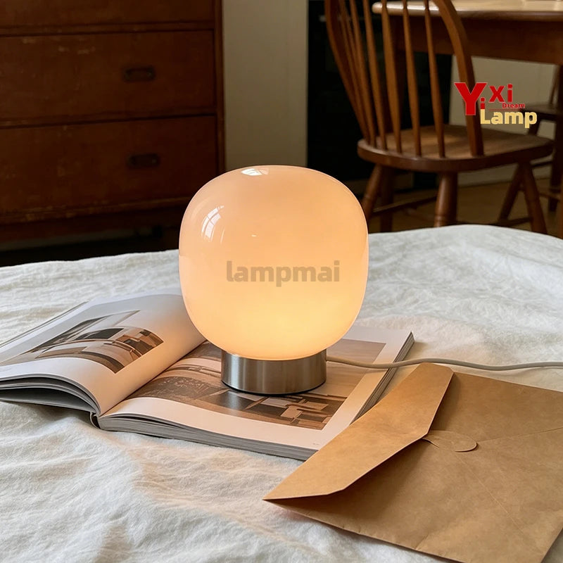 Lampe de table en verre à 3 teintes – lampe allumée en lumière chaude sur un lit