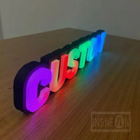 Lettres boîtier 3D – mot lumineux multicolore posé sur une table